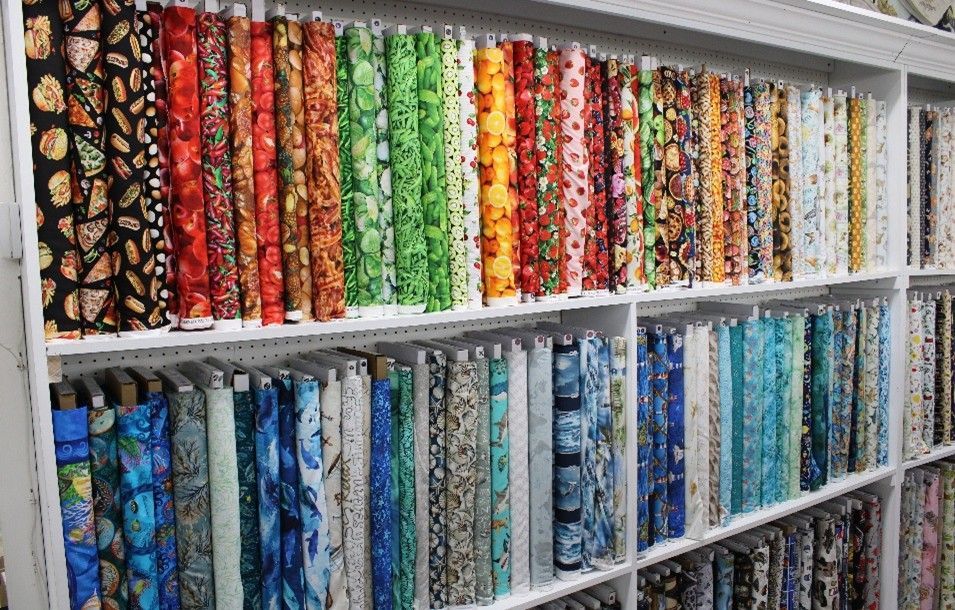 Fabric store shelves stacked with colorful textiles in neat, vibrant rows. Fabric store shelves stacked with colorful textiles in neat, vibrant rows.