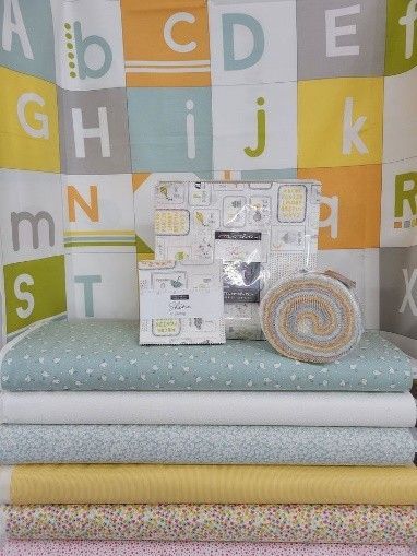 Different quilting with yellow, blue and letters from a local quilt shop.