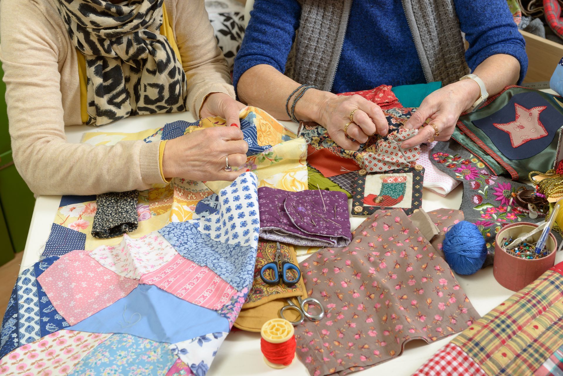 Two women are working on their quilting, using fabrics from a supplier. Two women are working on their quilting, using fabrics from a supplier.
