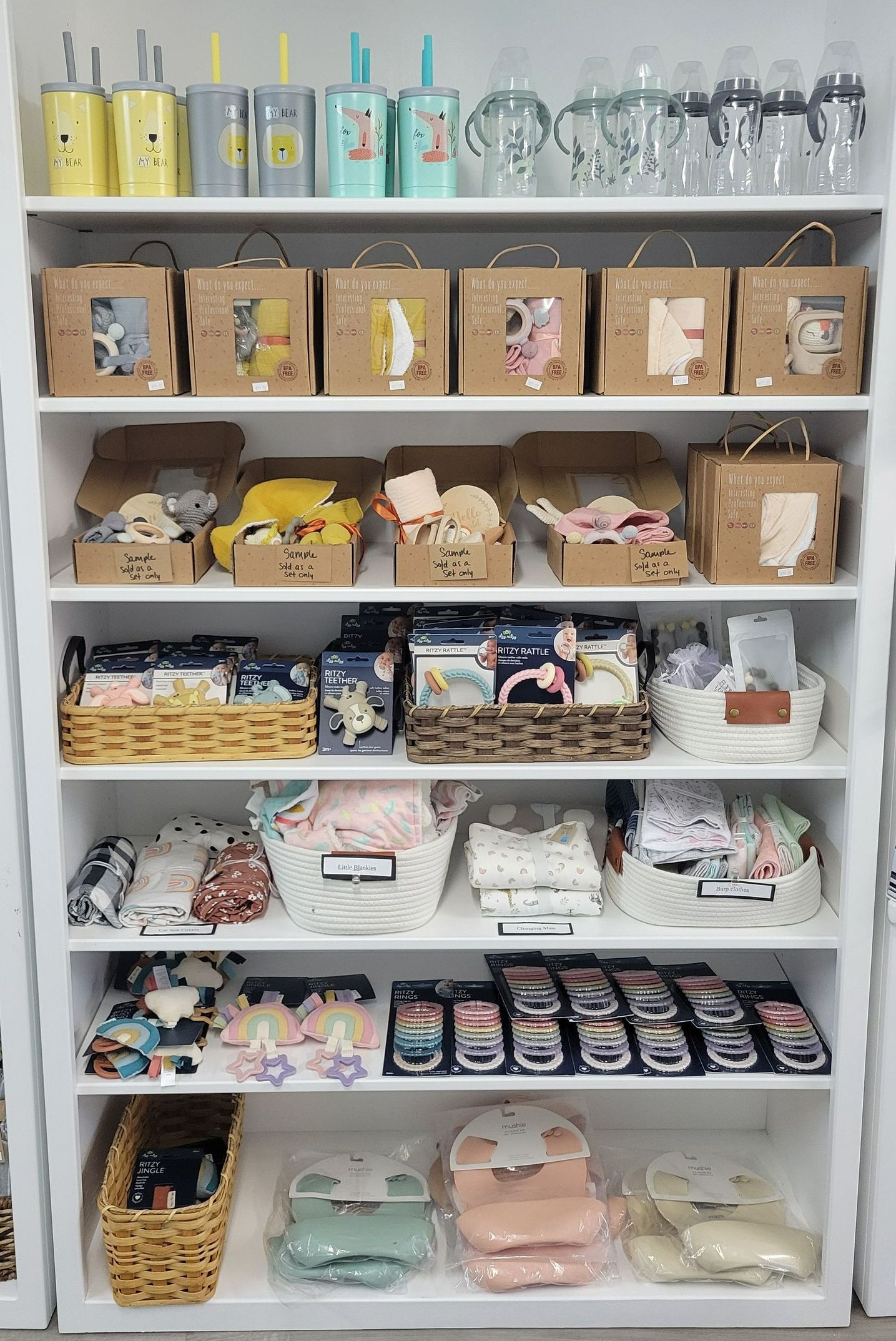 Shelf of neatly arranged packaged goods and glass jars in a bright store display