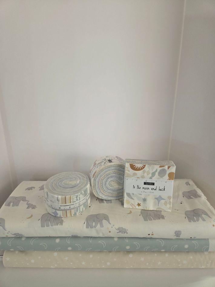 Three decorative paper boxes on a gray polka dot table against a white wall