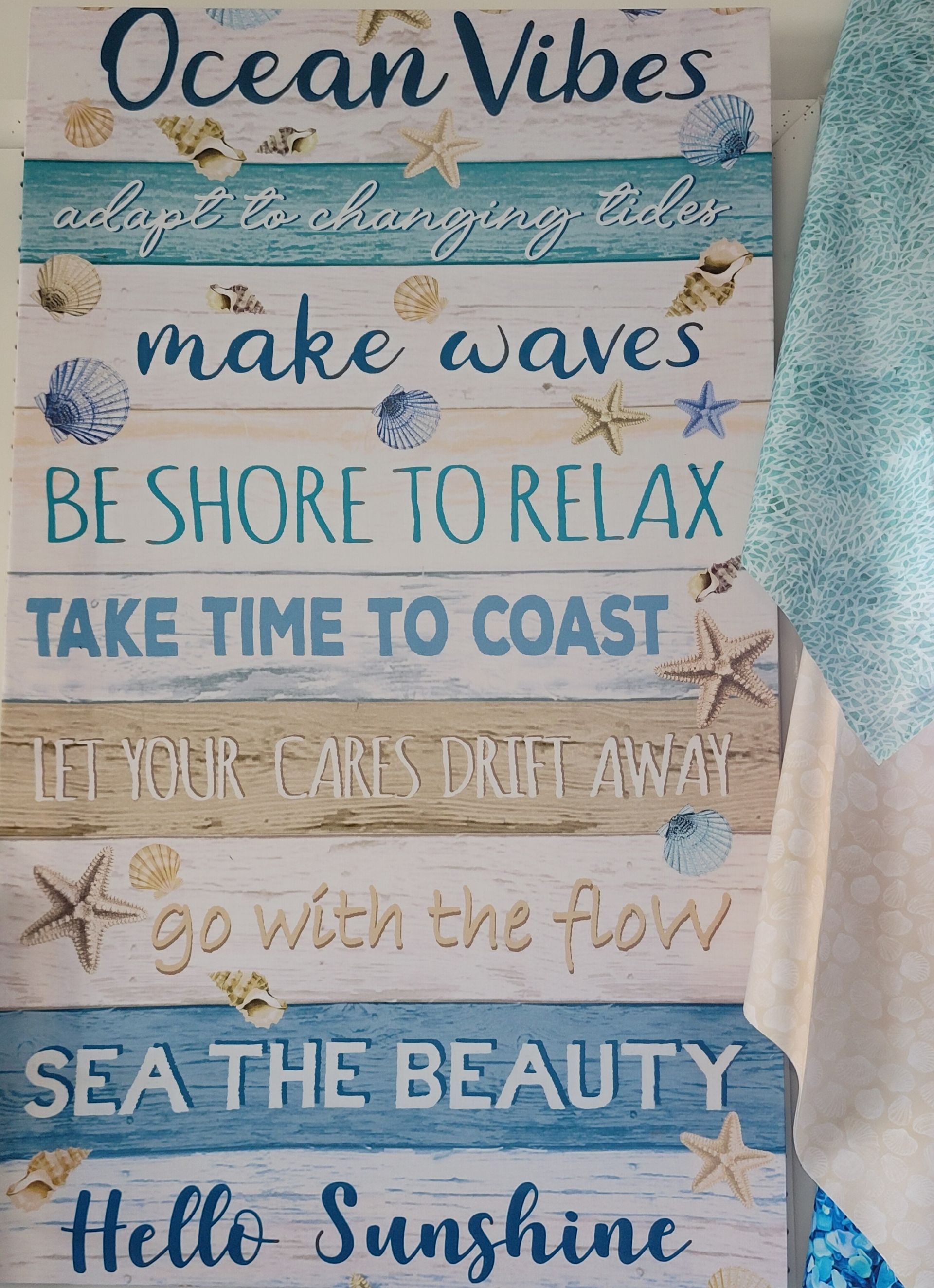 Ocean-themed wooden wall sign with blue text and seashells reading “Ocean Vibes” and beach quotes
