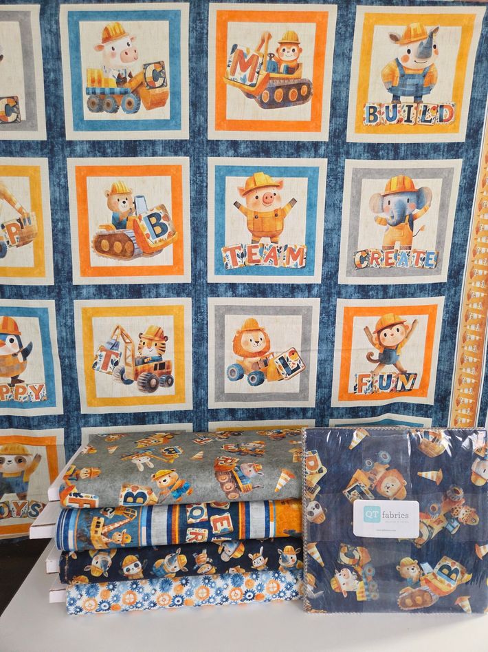 Orange-and-blue baby bedding set with cartoon panels, including crib quilt, pillow, and matching blanket display