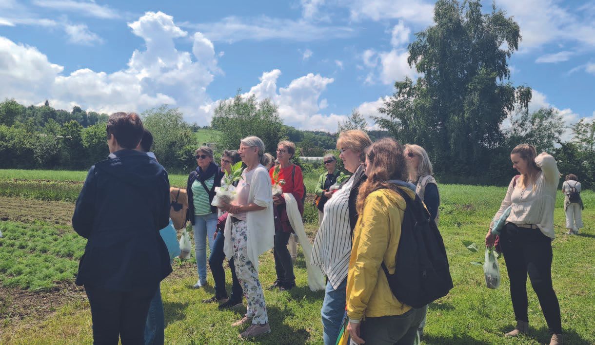 Eine Gruppe von Leuten steht auf einer Wiese.
