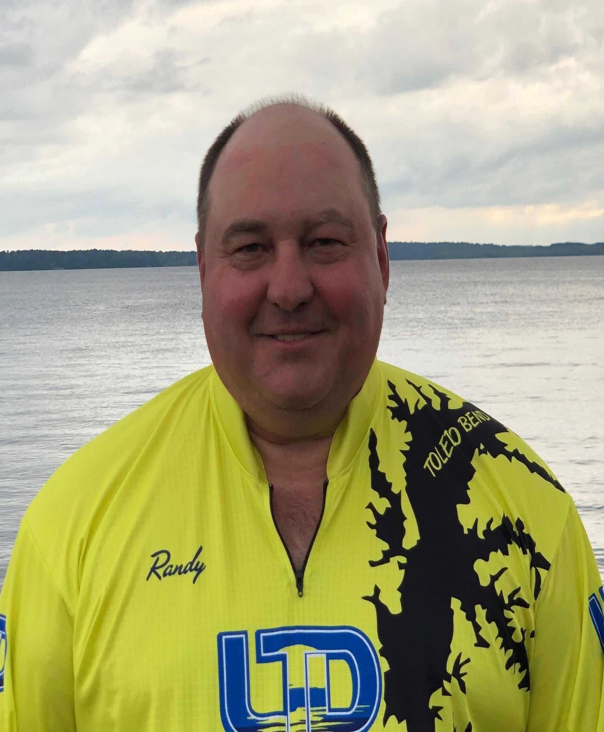 a man wearing a yellow shirt with the letter d on it