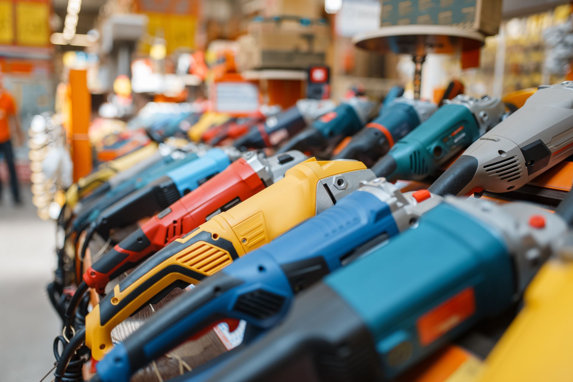 Rows of colorful electric drills displayed on a store shelf in a hardware store Rows of colorful electric drills displayed on a store shelf in a hardware store