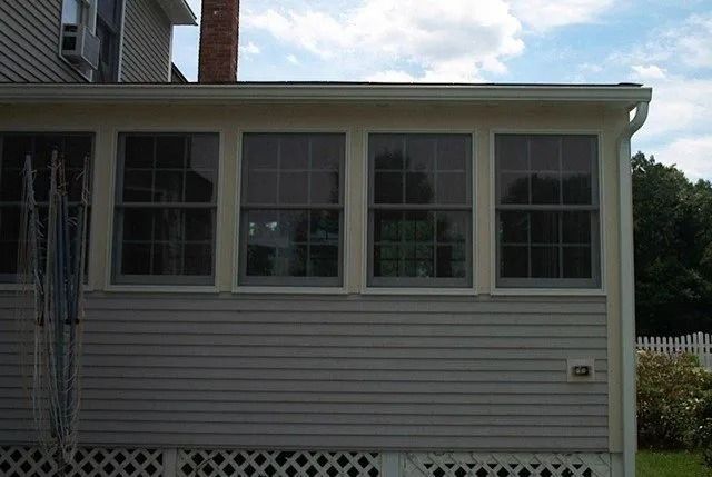 White house exterior with screened porch windows and lattice skirting