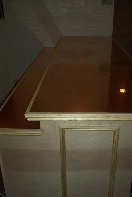 Wood-paneled stair landing with a wooden tabletop or shelf and a small round light on the right.