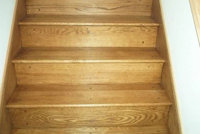 Wooden indoor staircase with four steps and white side walls