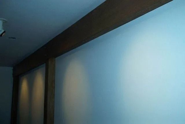 Blue wall with dark wooden beams and a corner of a room indoors