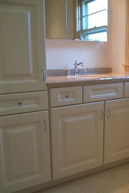 Bathroom vanity with sink, mirror, and cream-colored cabinets