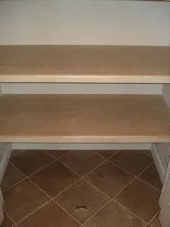Built-in carpeted stairs with two steps leading to a small landing niche