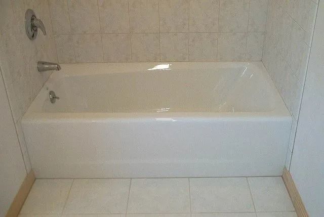 White bathtub with tiled surround in a bathroom