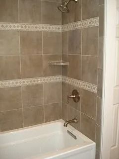Tiled bathroom shower and bathtub with chrome fixtures and built-in corner shelf