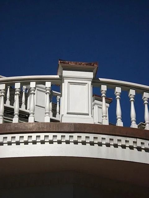 White balcony railing against a deep blue sky