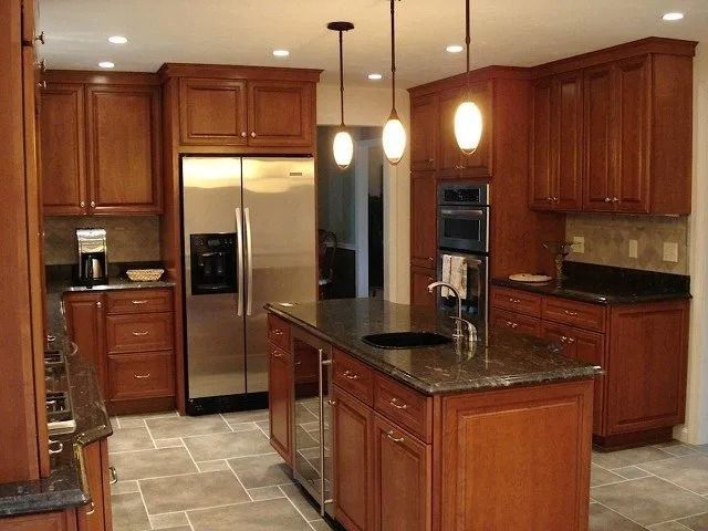 Warm wood kitchen with stainless steel appliances, granite island, and hanging pendant lights
