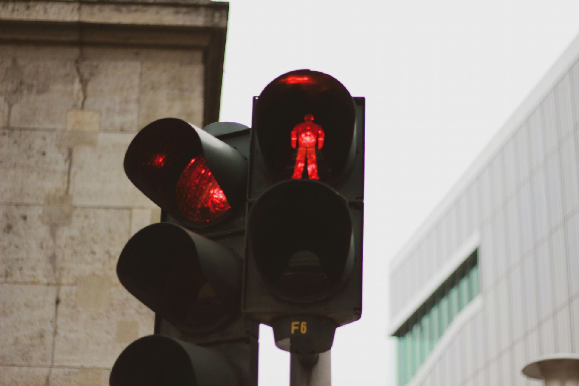 A red pedestrian traffic light is turned on in a city.