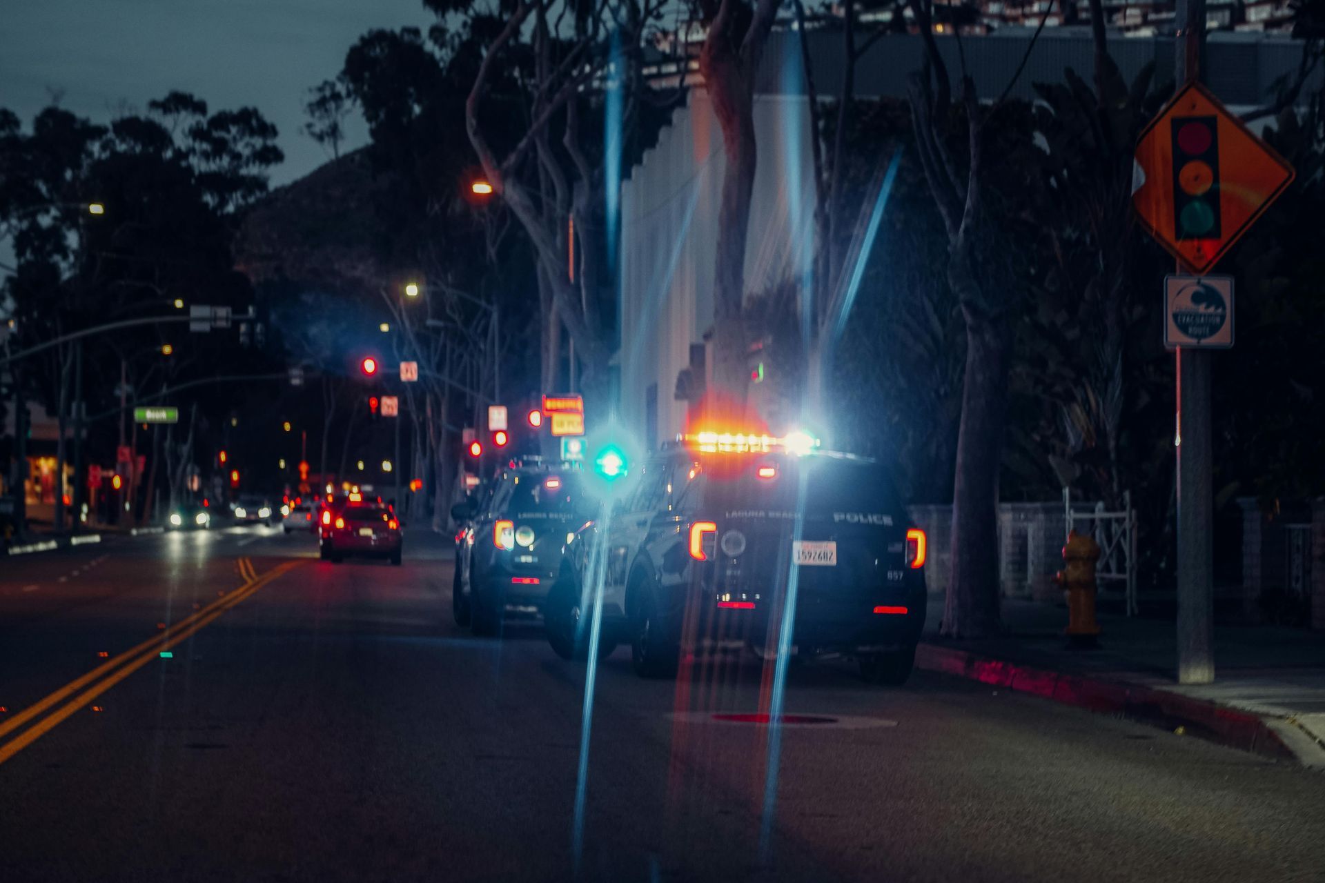 A police car is driving down a city street at night.