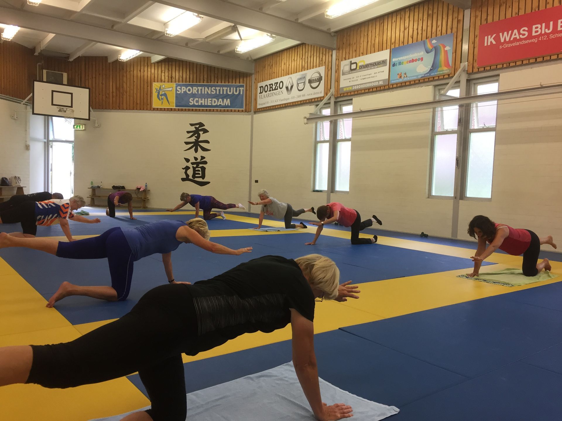 Een groep mensen doet yoga in een sportschool.