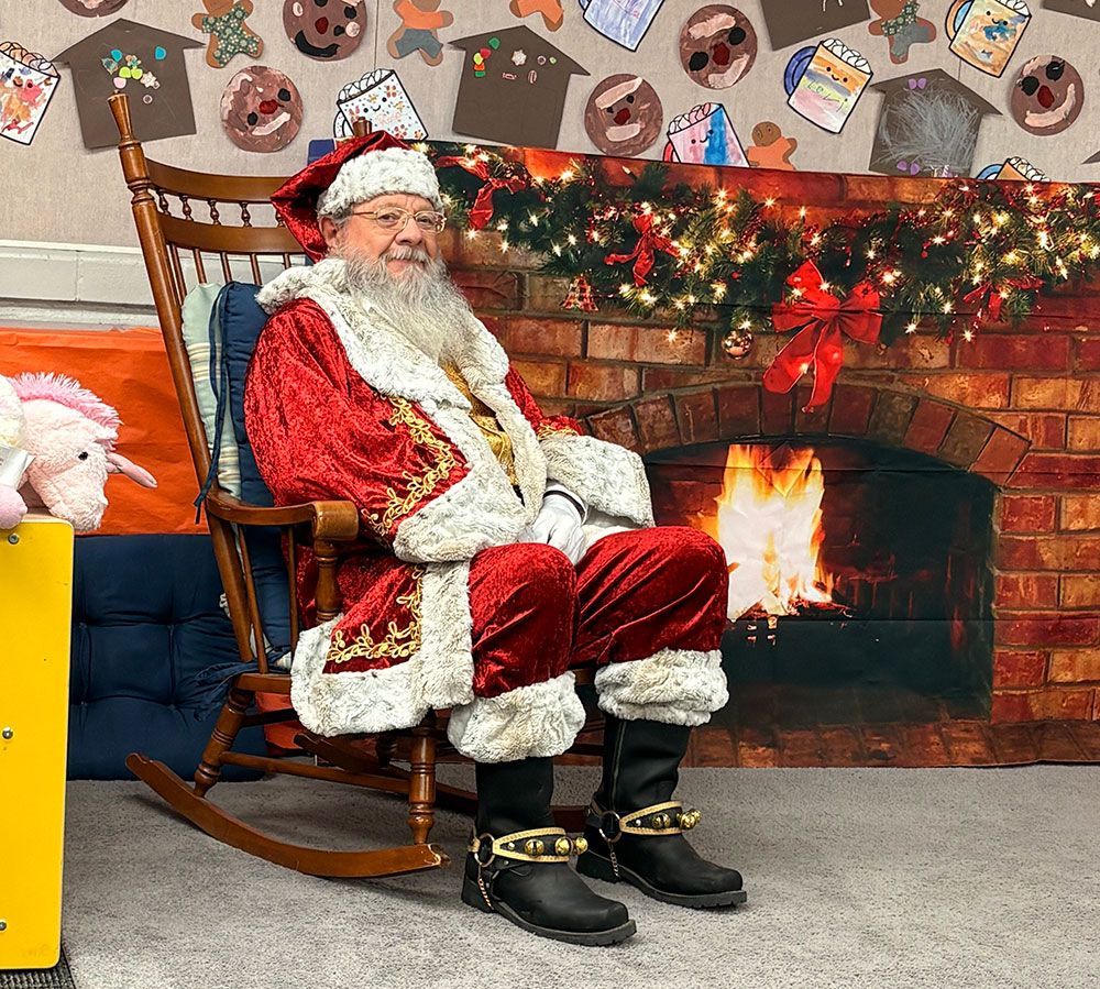 Santa Claus sitting in front of the fireplace.