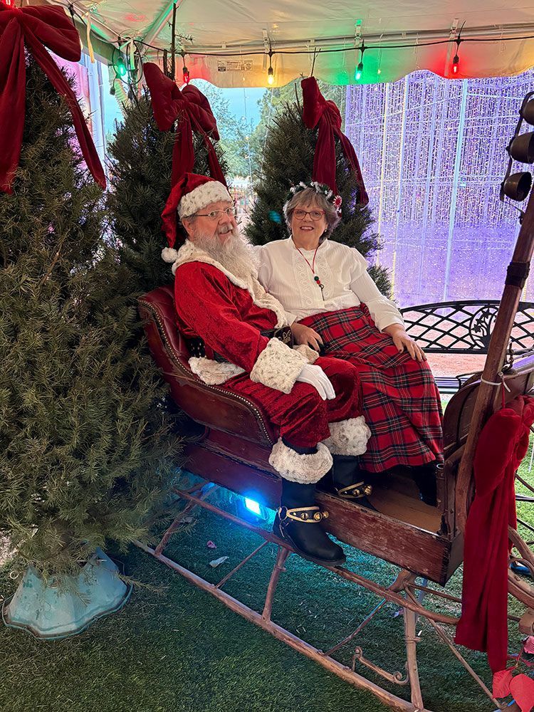 Santa and Mrs. Claus sitting on a winter sled