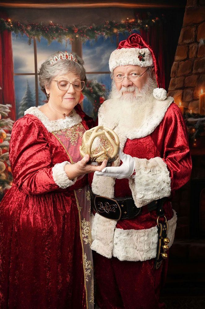 Santa and Mrs. Claus hold a special gift.
