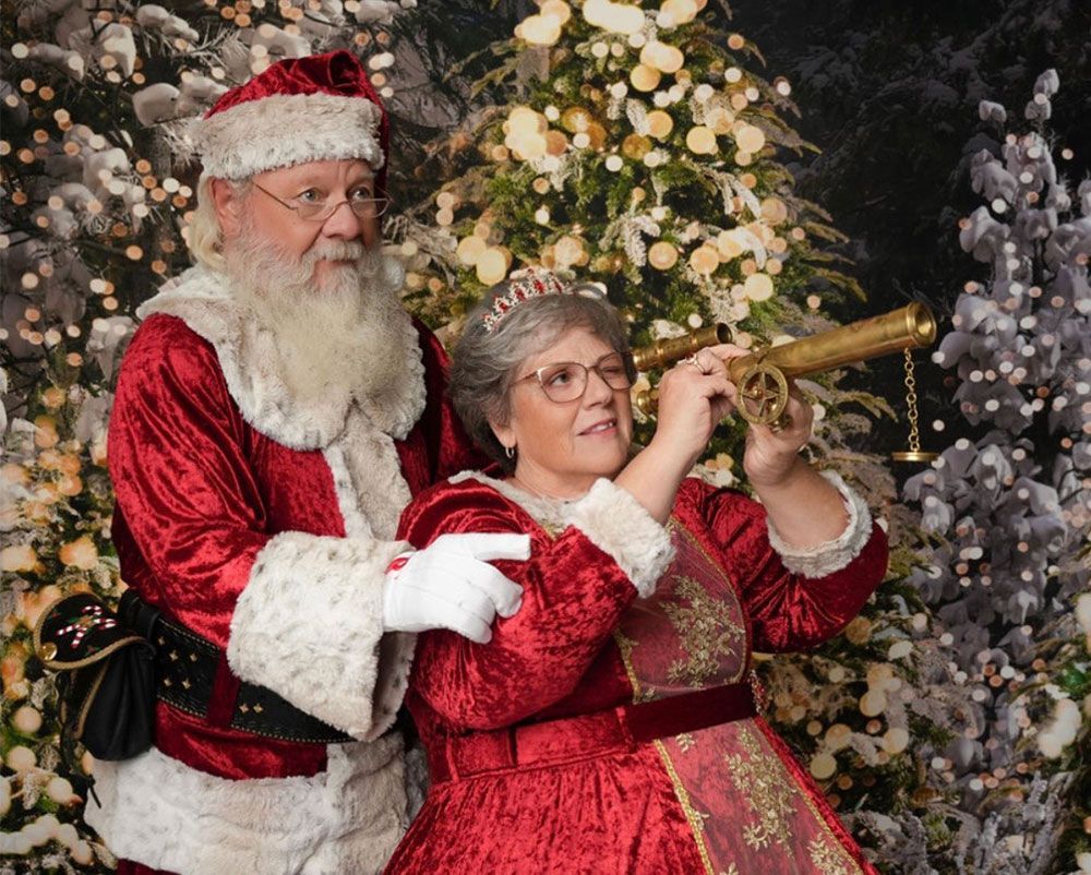 Santa and Mrs. Claus looking through a telescope