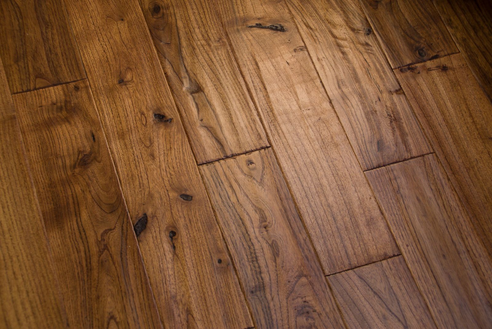 Close-up of a hardwood floor with varying shades of brown planks, angled to the right.
