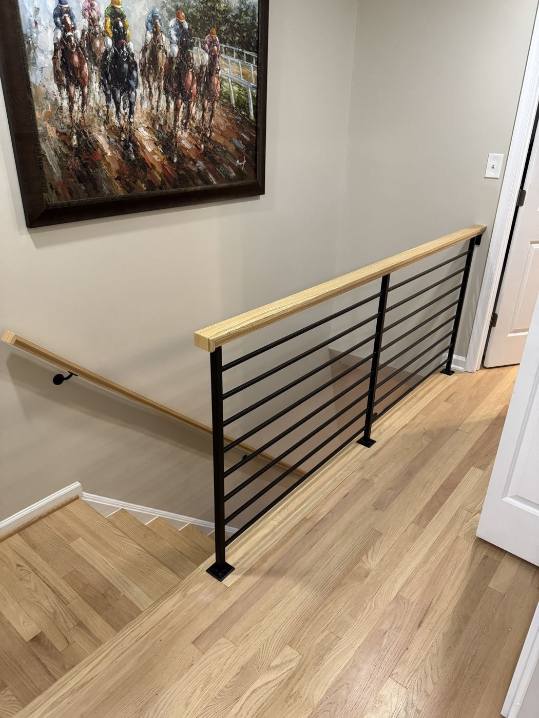 Modern horizontal iron railing with oak cap