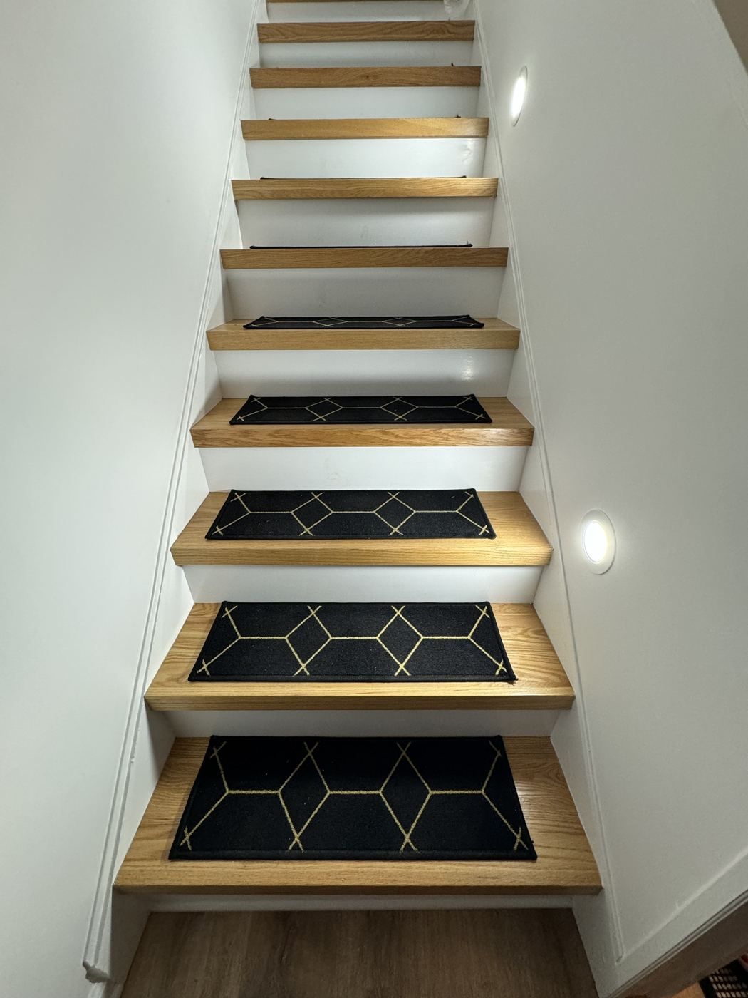 Oak treads and white risers lit by recessed stair lights