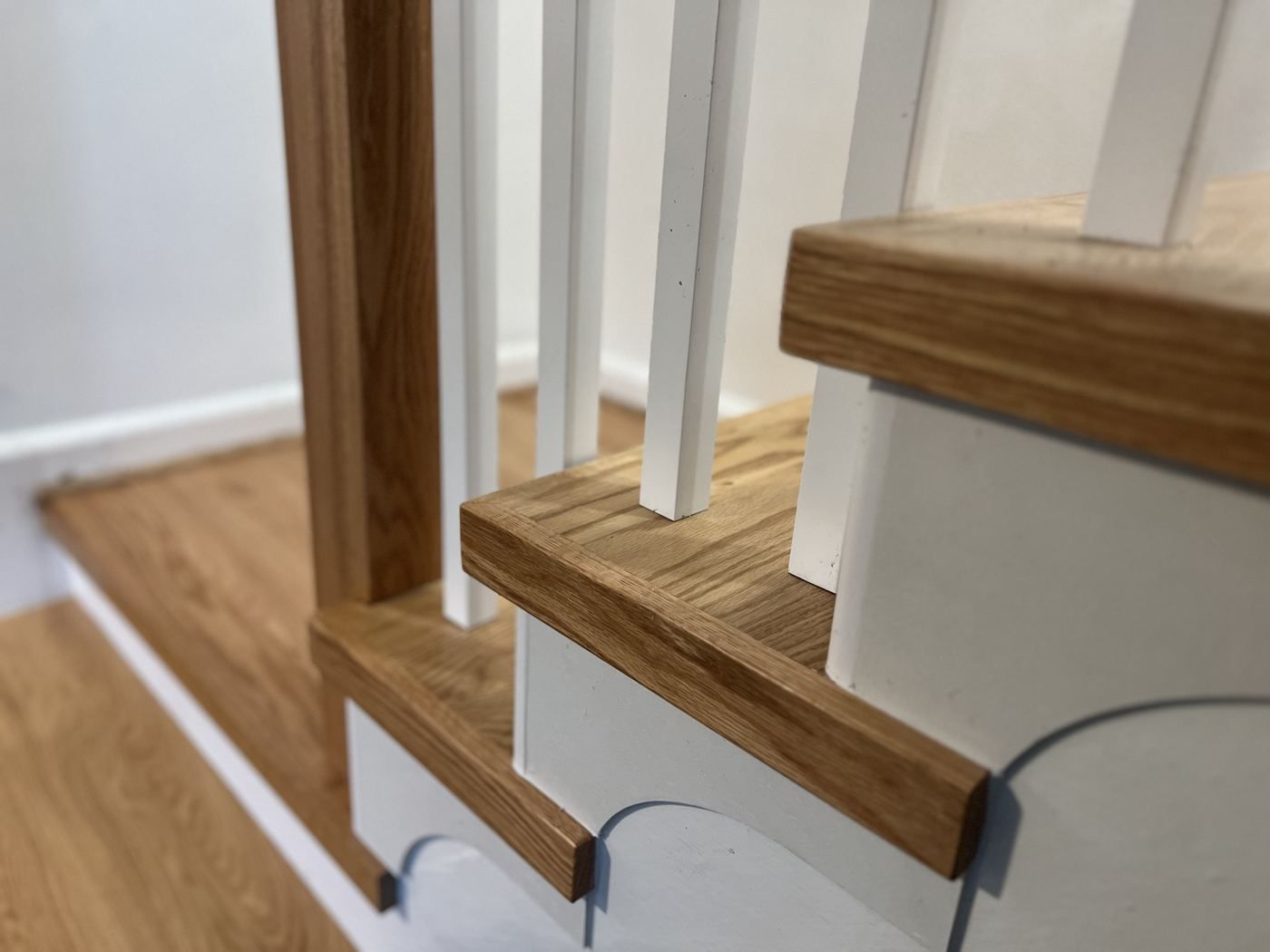 Oak tread return over a scrolled skirt bracket
