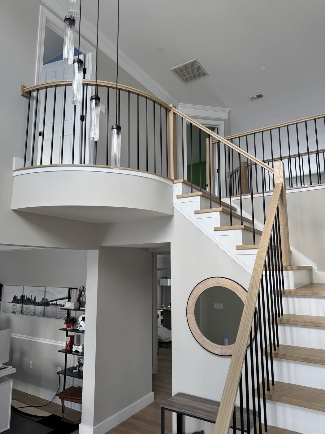Curved balcony with iron railing over a two-story foyer
