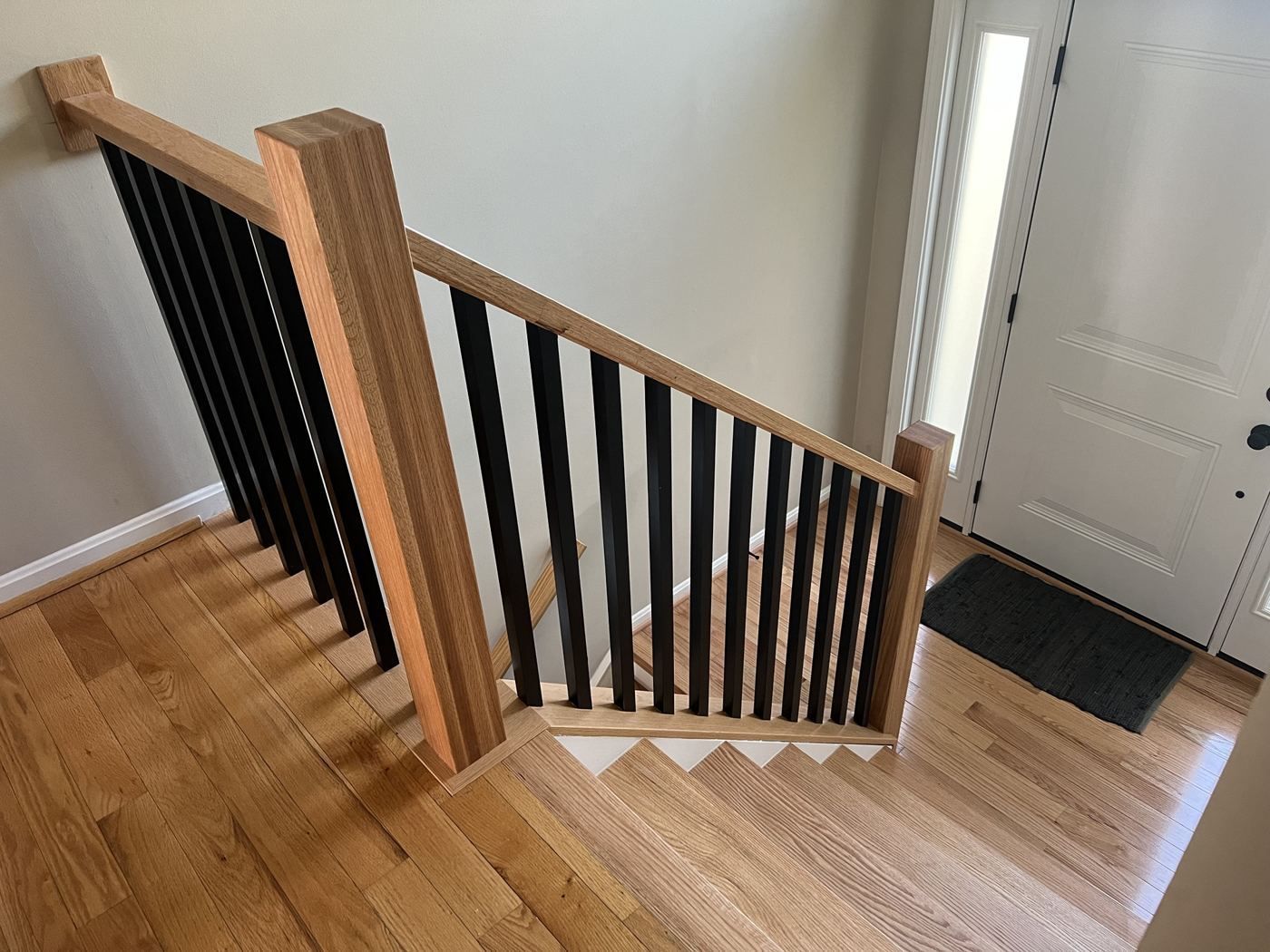 Oak box newel and handrail with square black balusters