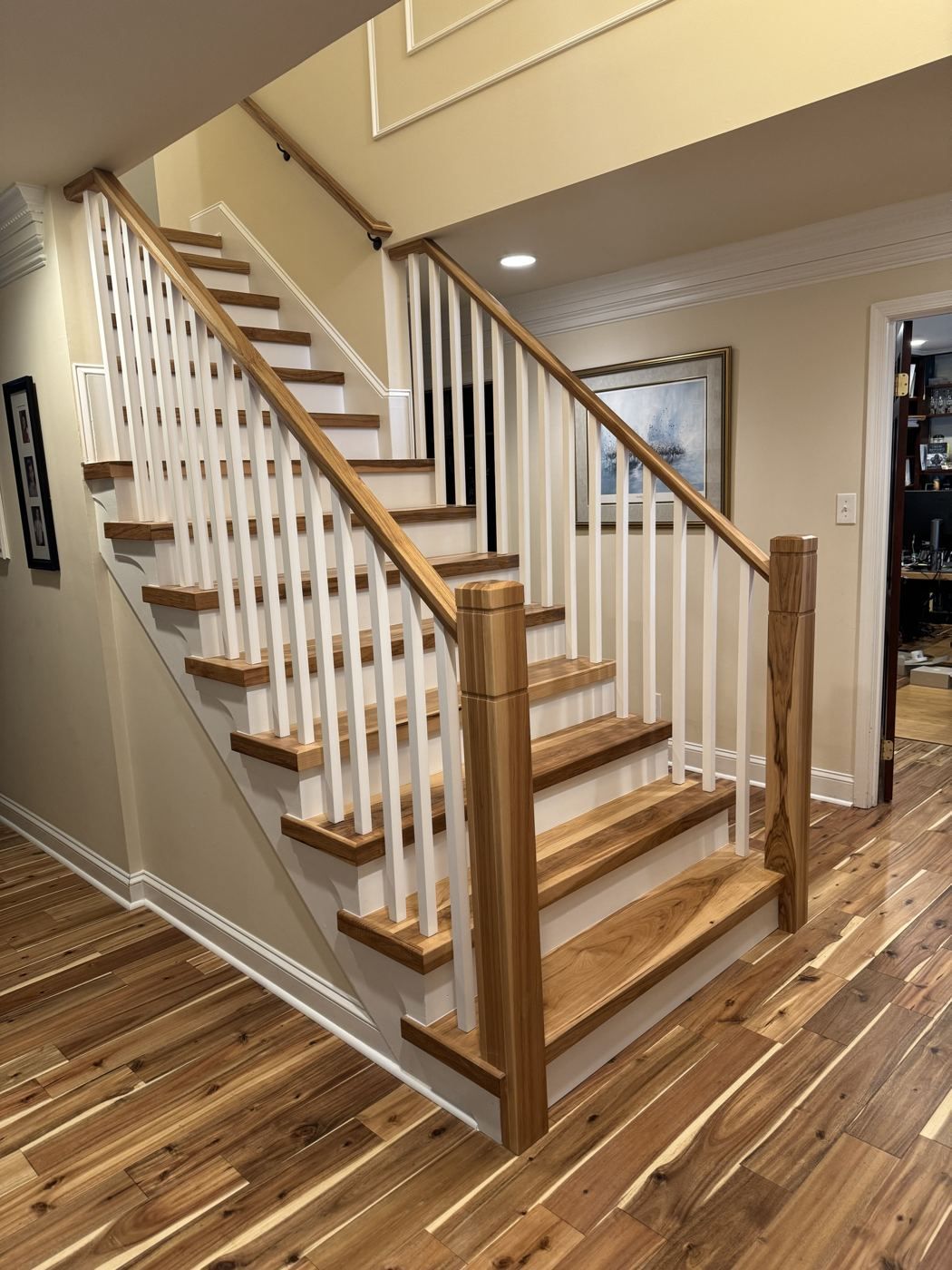Oak stair with white balusters over hickory floors