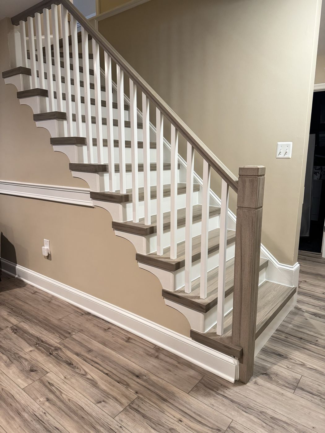 Gray-washed treads with square white balusters and scrolled brackets