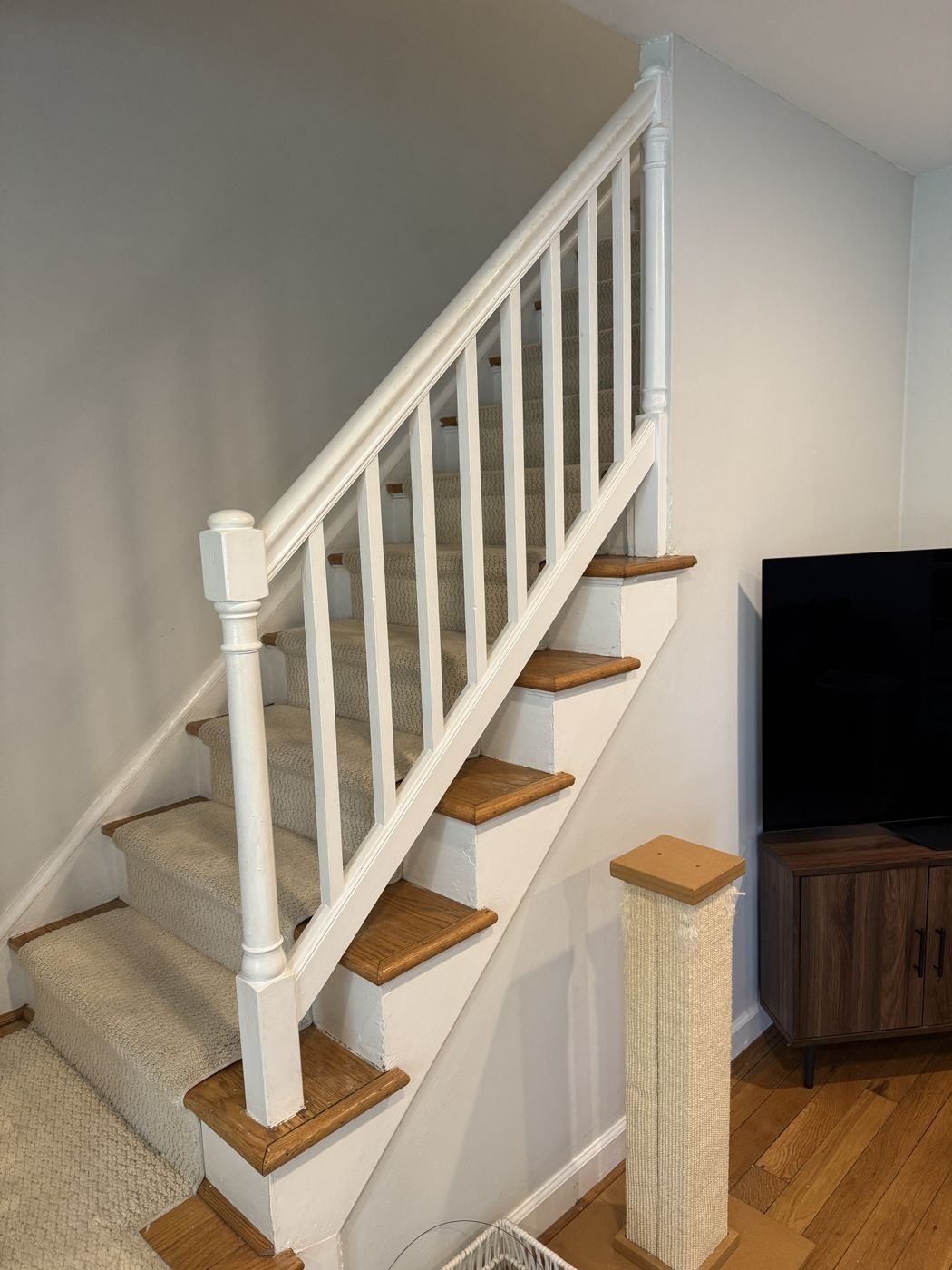 Before: carpeted straight stair with painted white railing