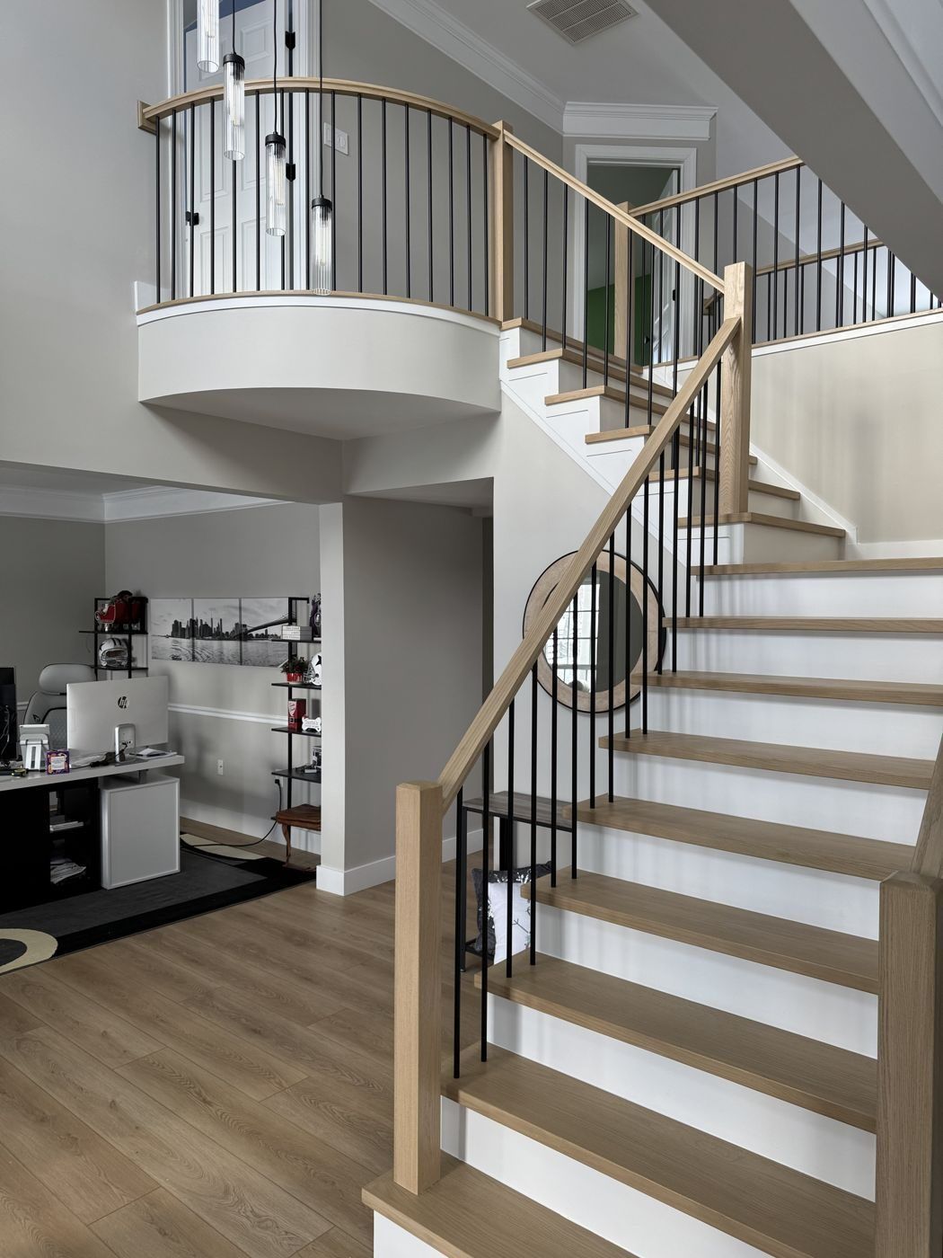 After: white oak box newels and treads with black balusters at the bottom of the stair