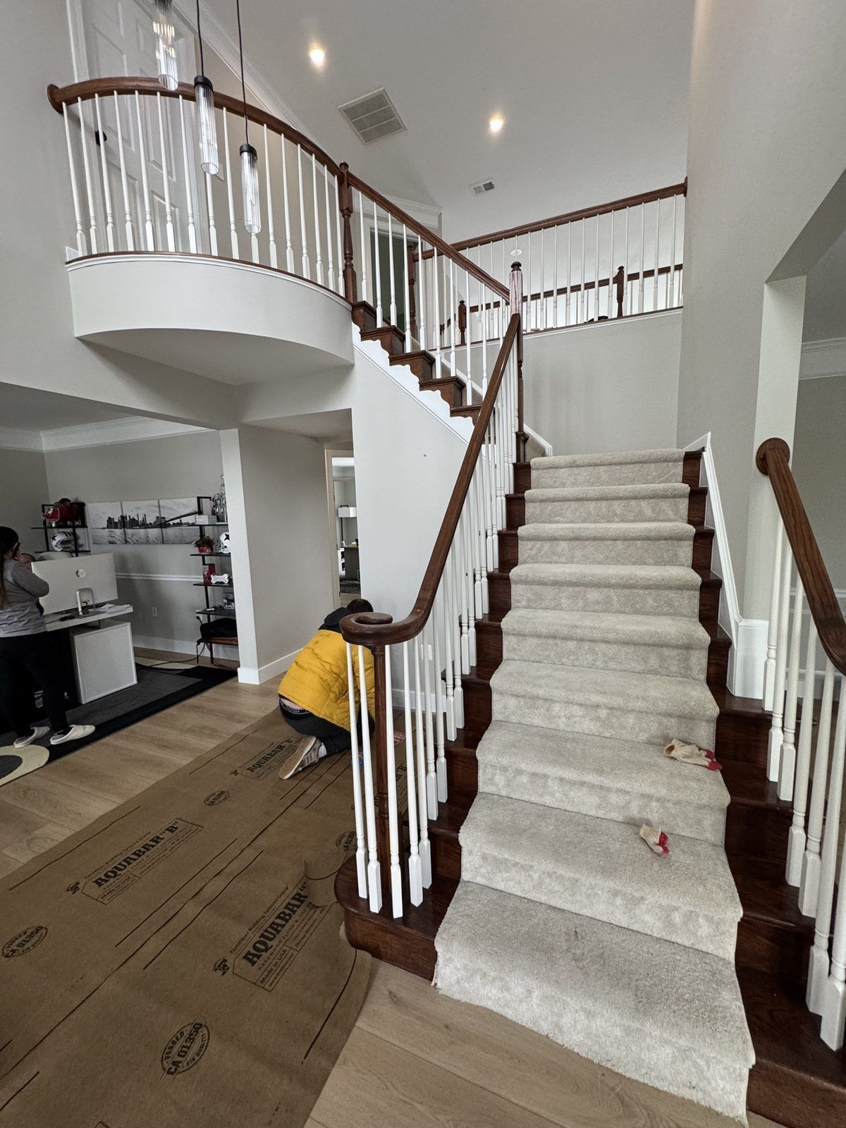 Before: dark turned newel, spindles and carpeted bottom steps