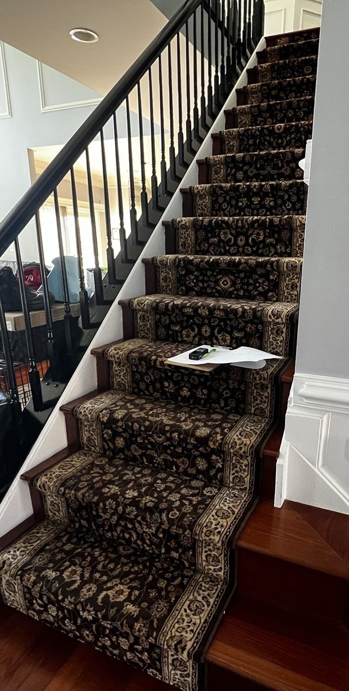 Before: patterned runner over dark treads with black balusters