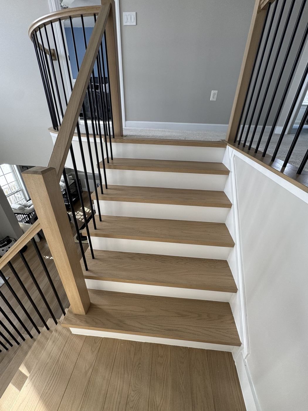 After: white oak treads and box newels with square black balusters