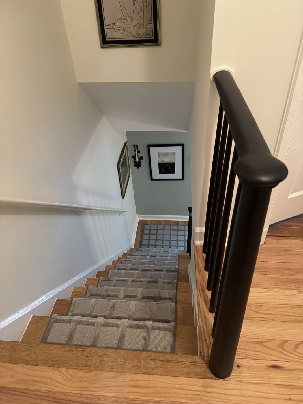 After: view down the stair with the new black railing and runner