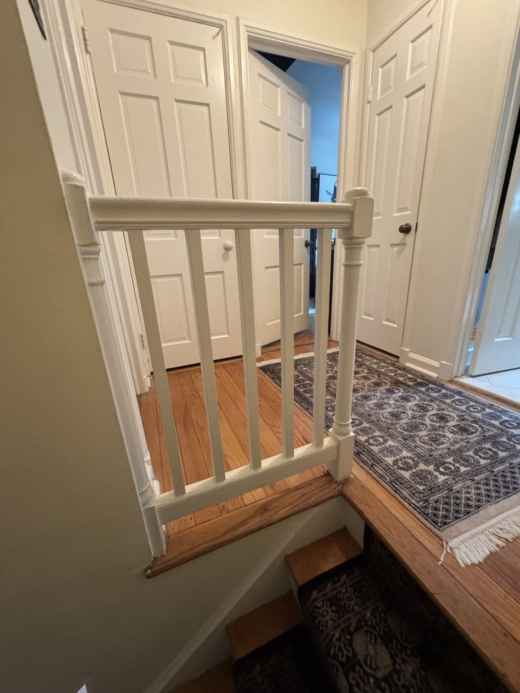 Before: painted landing railing at the top of the stair