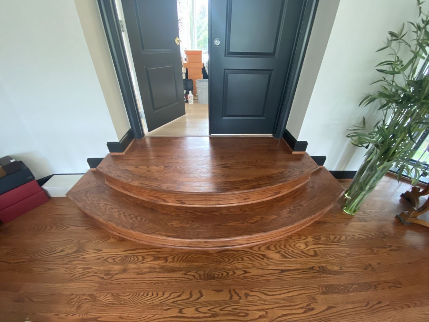 Before: curved red-oak steps in a dark orange stain