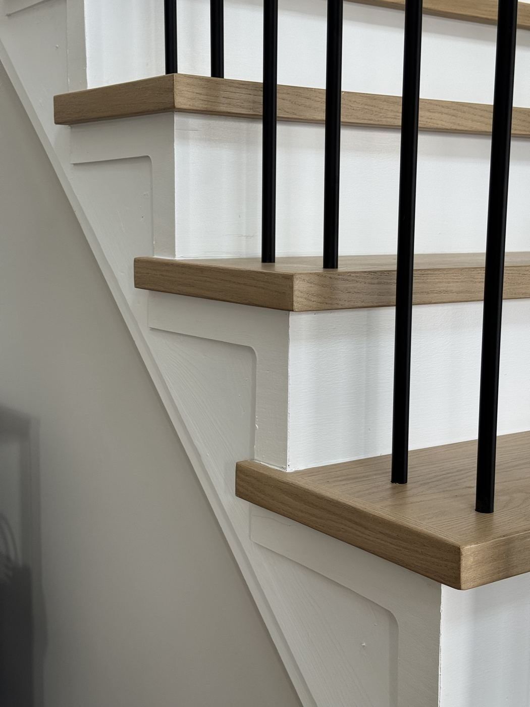 Close-up of square-edge white oak treads with black balusters
