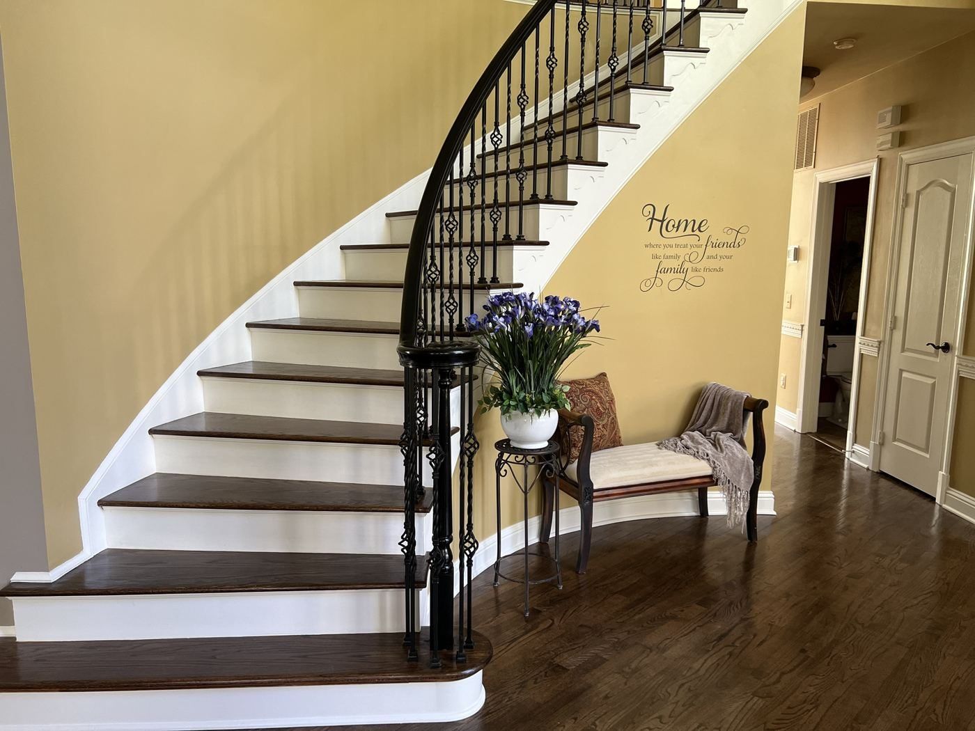 Curved staircase with dark treads and iron balusters