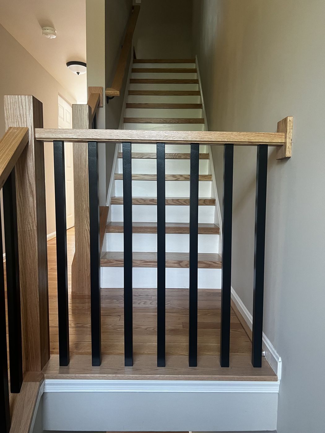 Oak newel and square black balusters from above