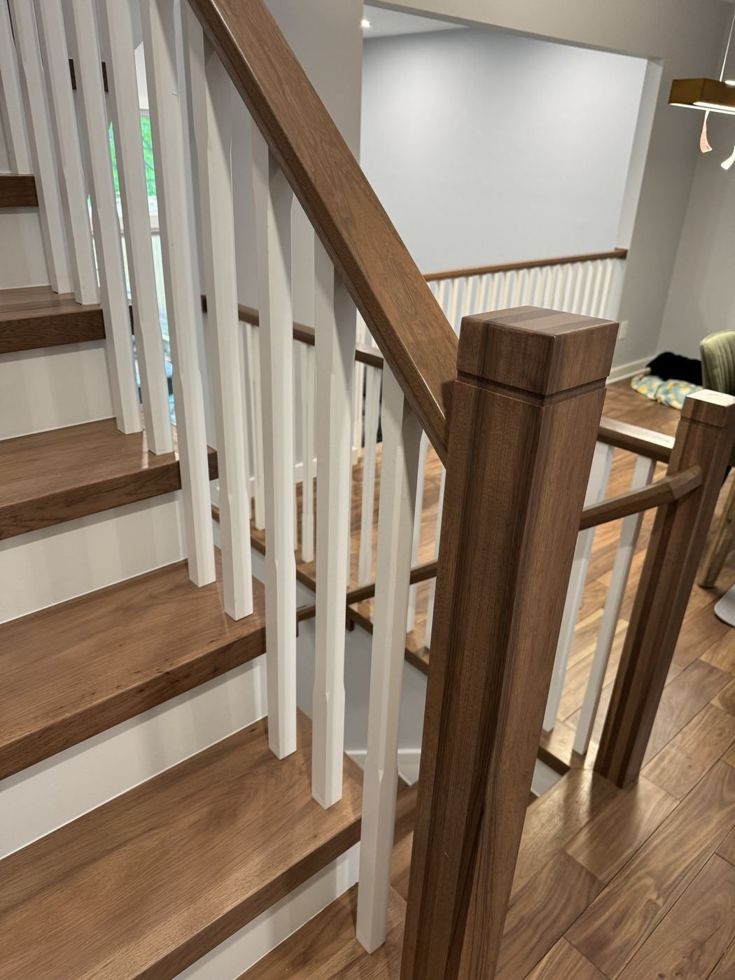 Walnut-toned newel post and handrail