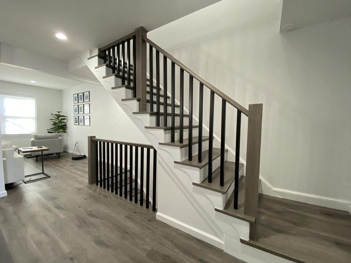 Open staircase with dark railing and gray plank floor