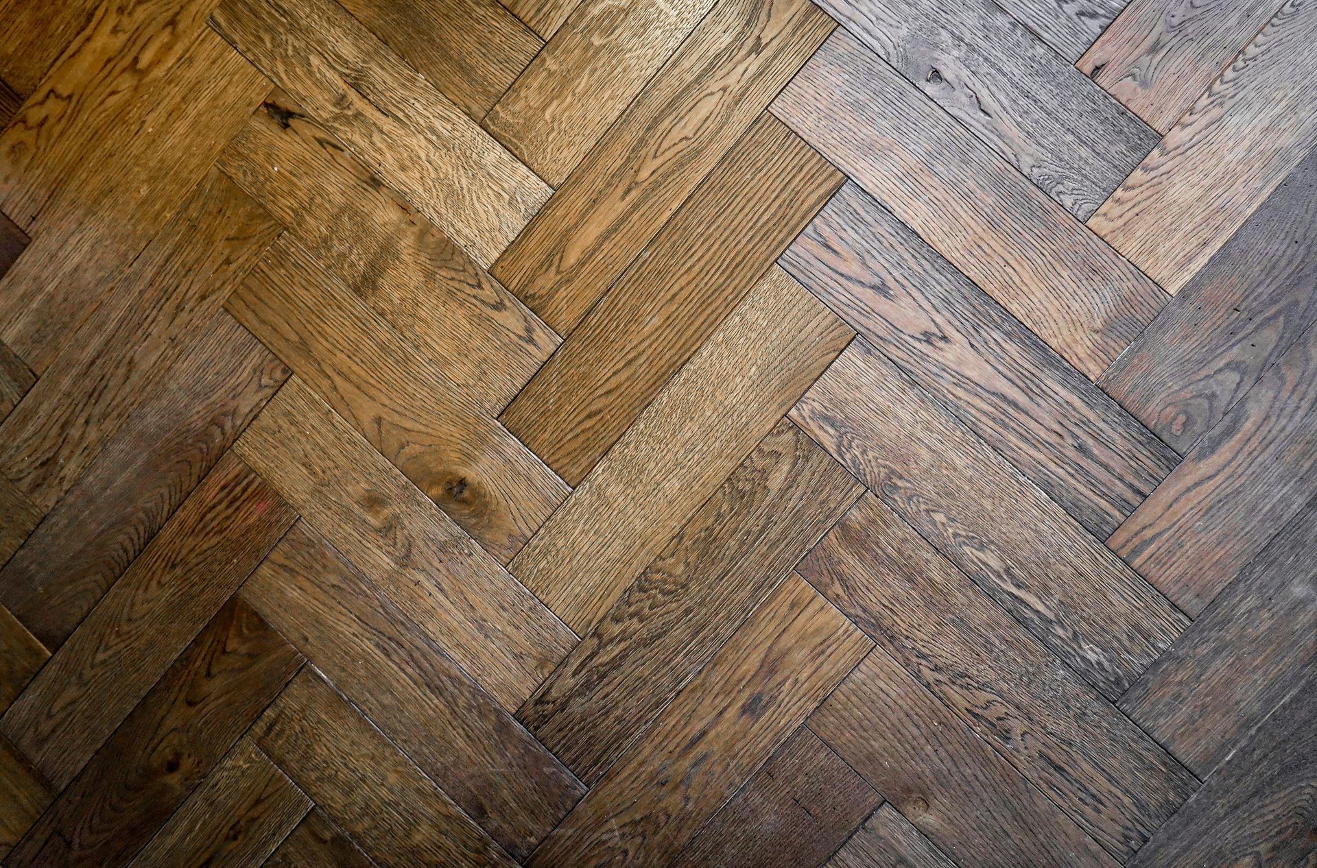 A close up of a wooden floor with a herringbone pattern.