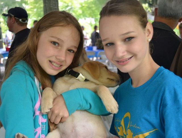 two kids holding a dog